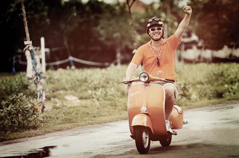 Albert Kok riding Vespa