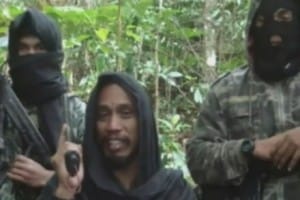 Santoso (middle) threatening the police through a YouTube video