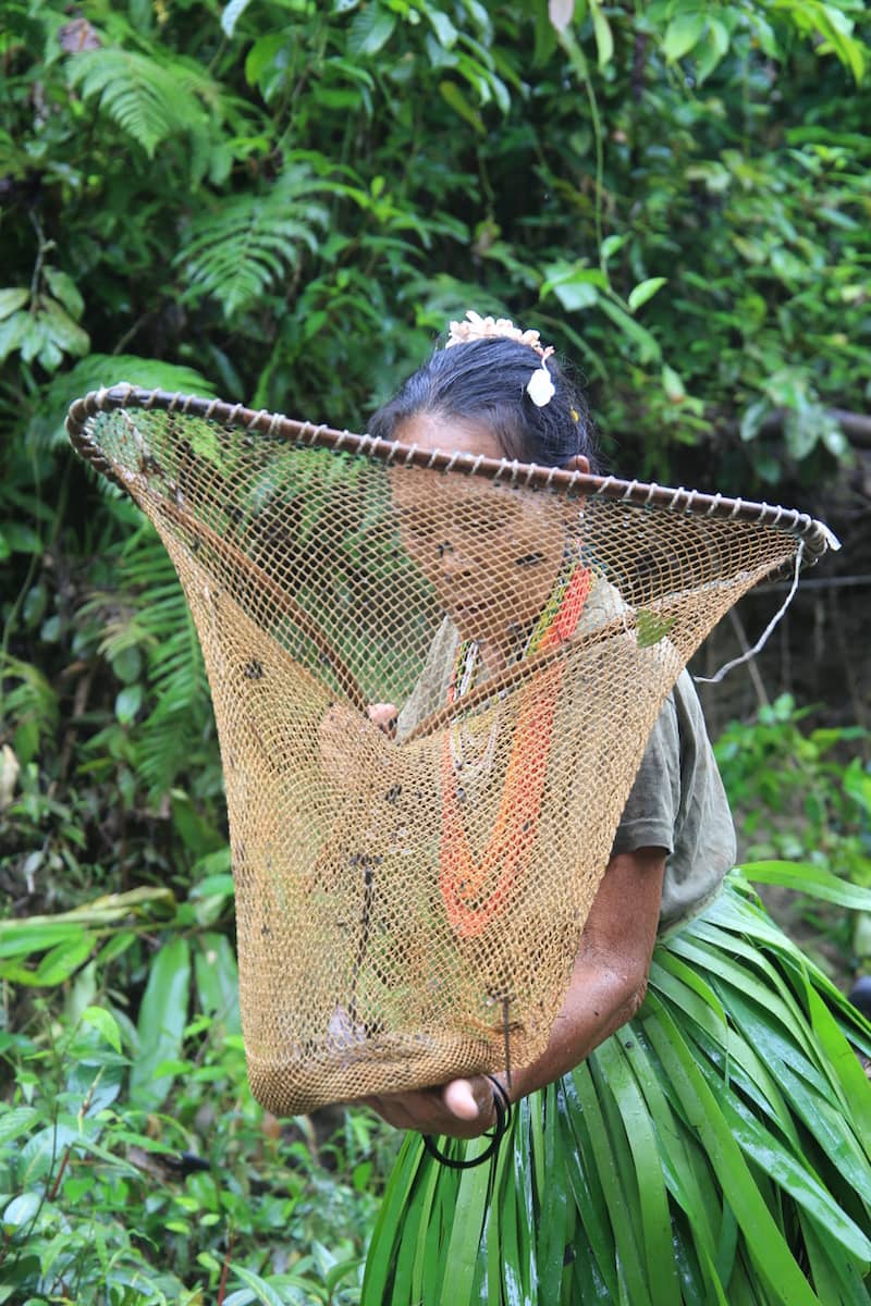 Mentawai woman fishing in a river